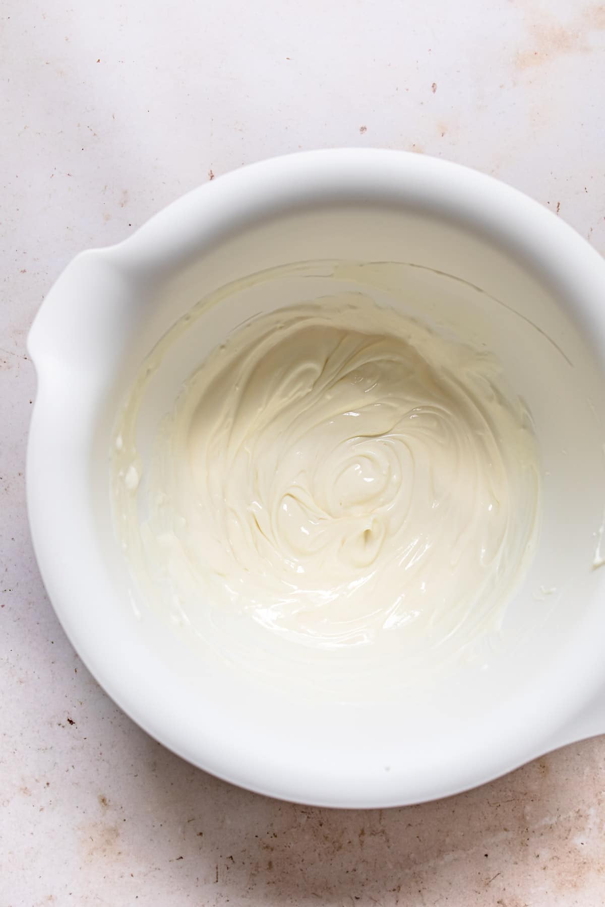 Cream cheese mixture in a white mixing bowl. 