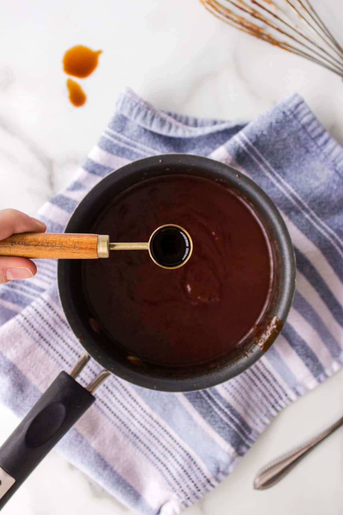 Stirring liquid smoke into barbecue sauce. 