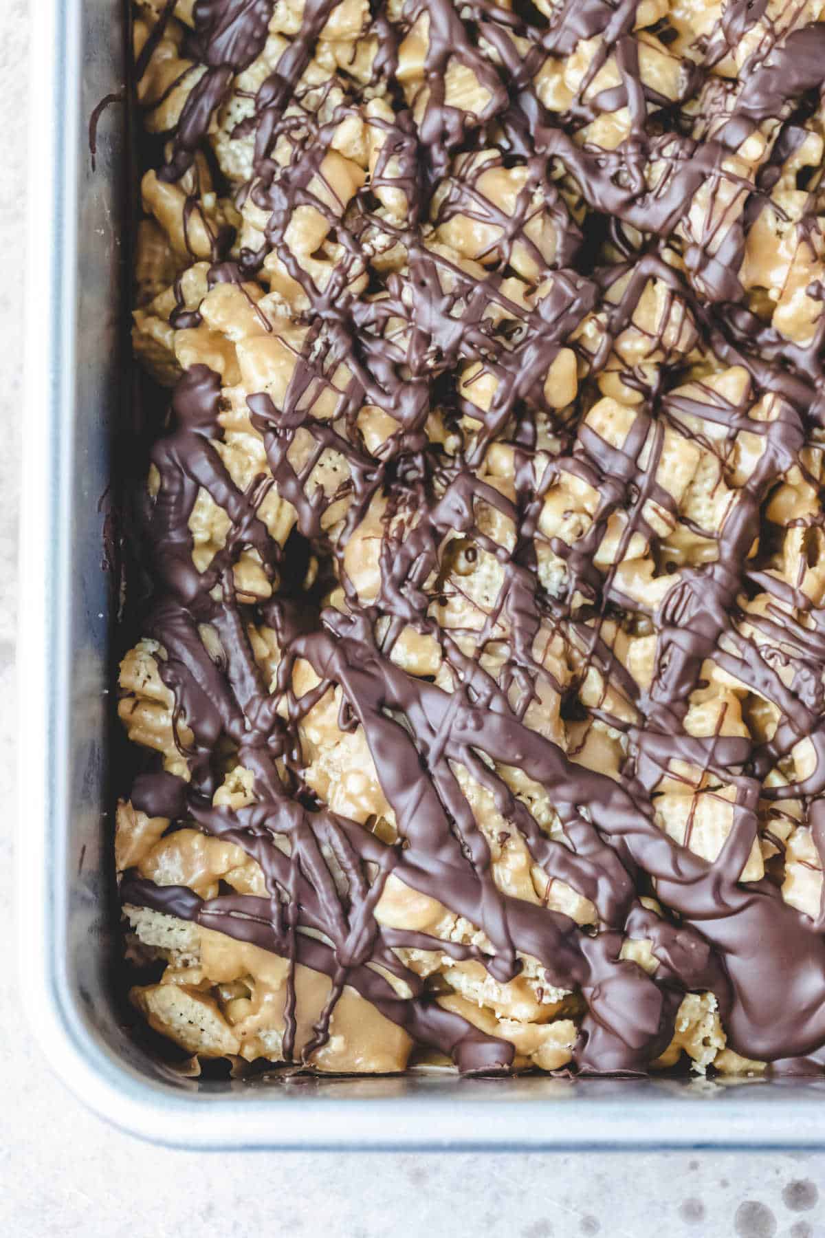 Edge of the pan of no bake chocolate peanut butter Chex treats. 