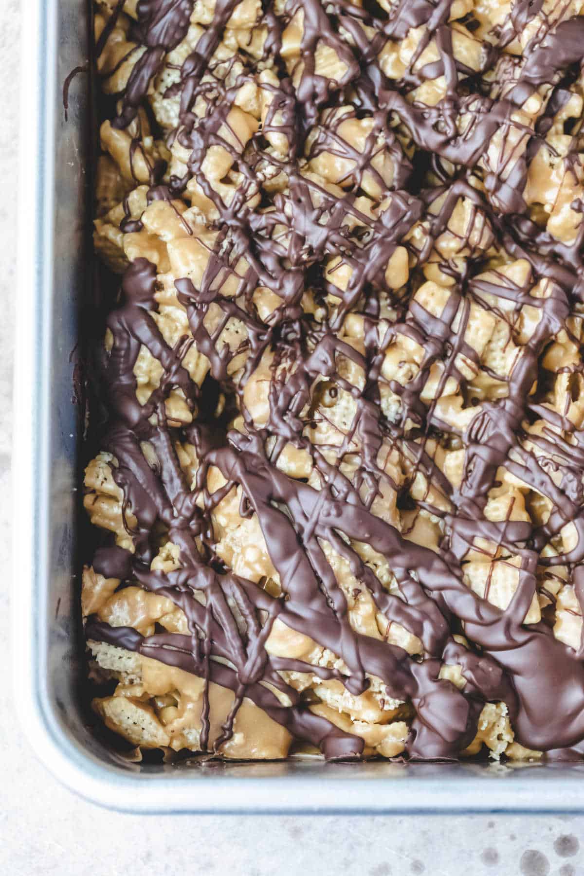 Edge of the pan of no bake chocolate peanut butter Chex treats.