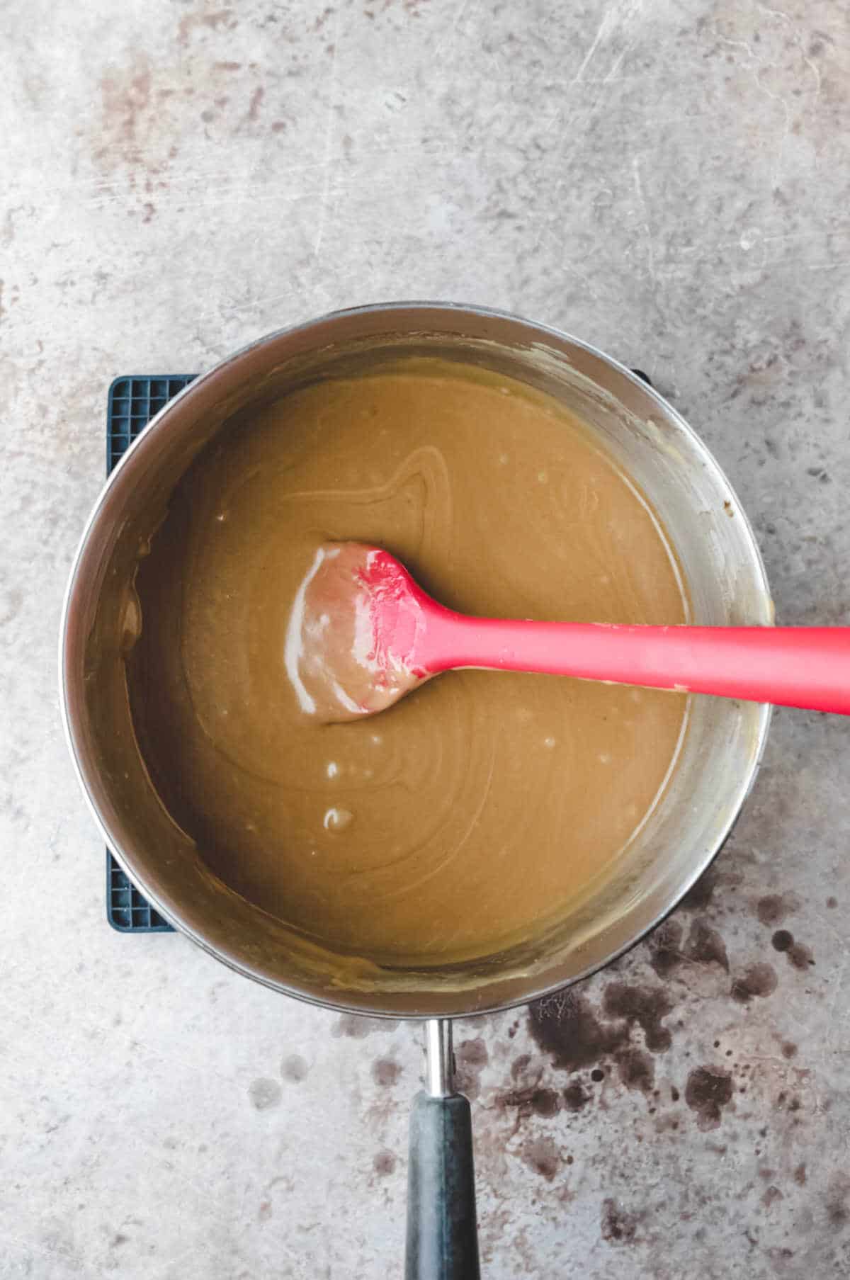 Peanut butter sauce in a silver saucepan.