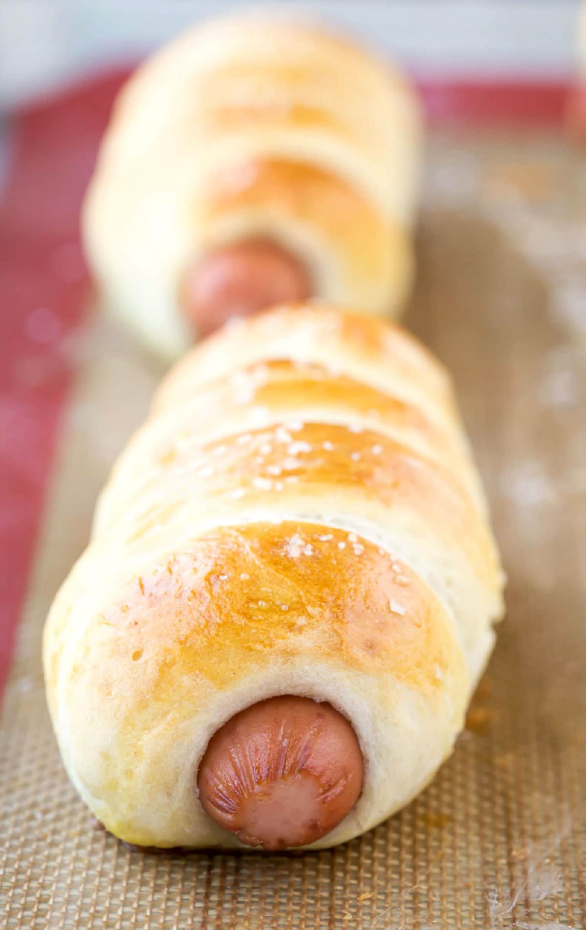 Homemade pretzel Dogs on a silicone baking mat.
