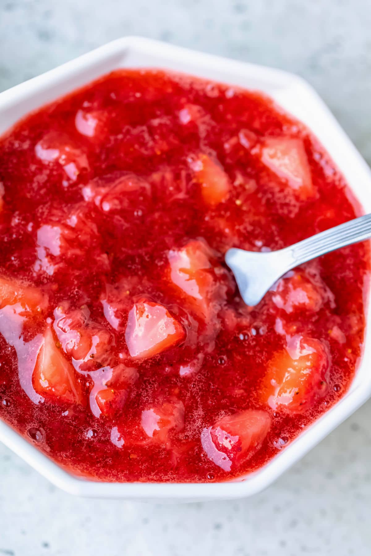 Close up picture of a dish of strawberry sauce.