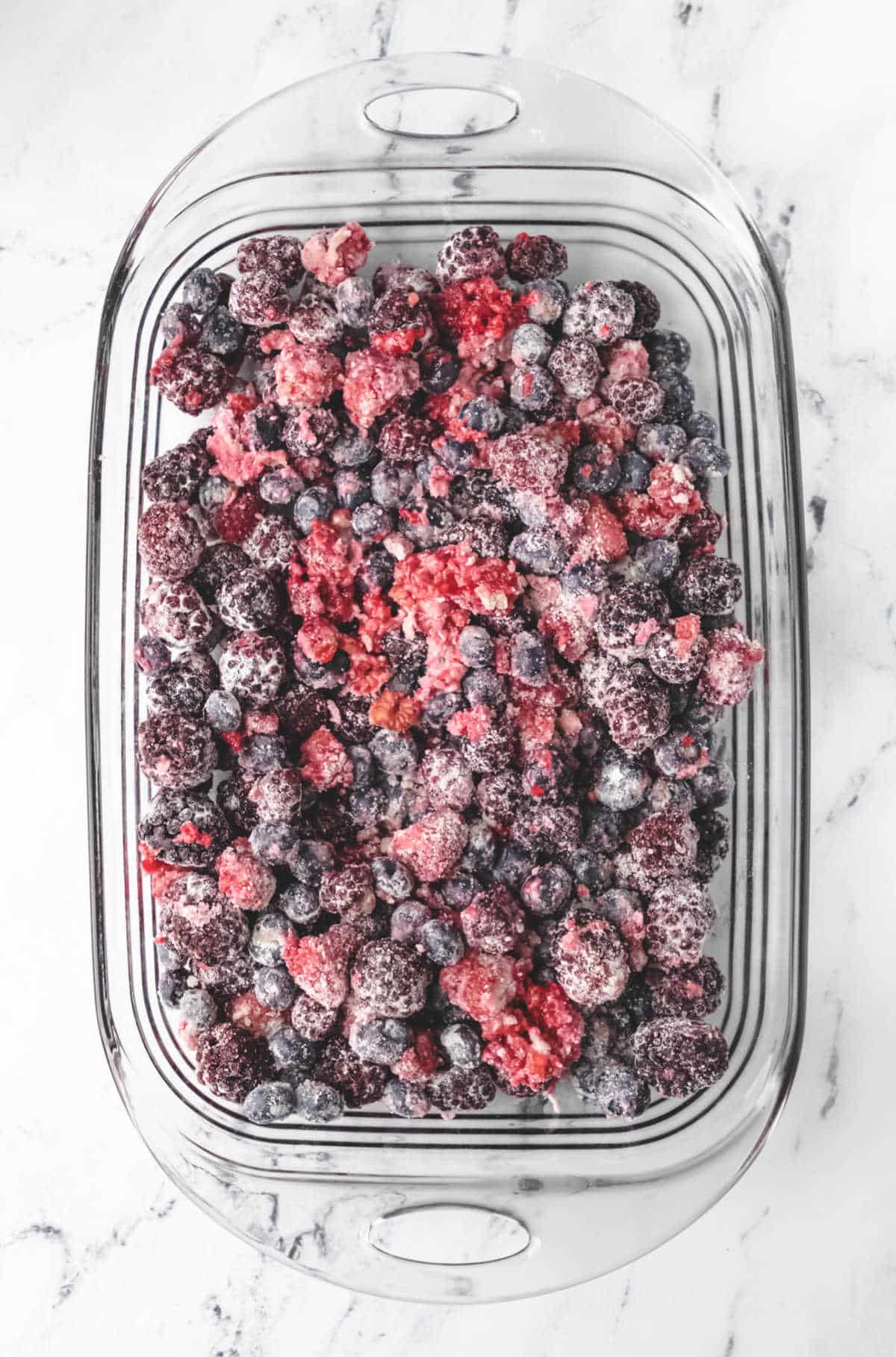 Berry mixture in a glass baking pan. 