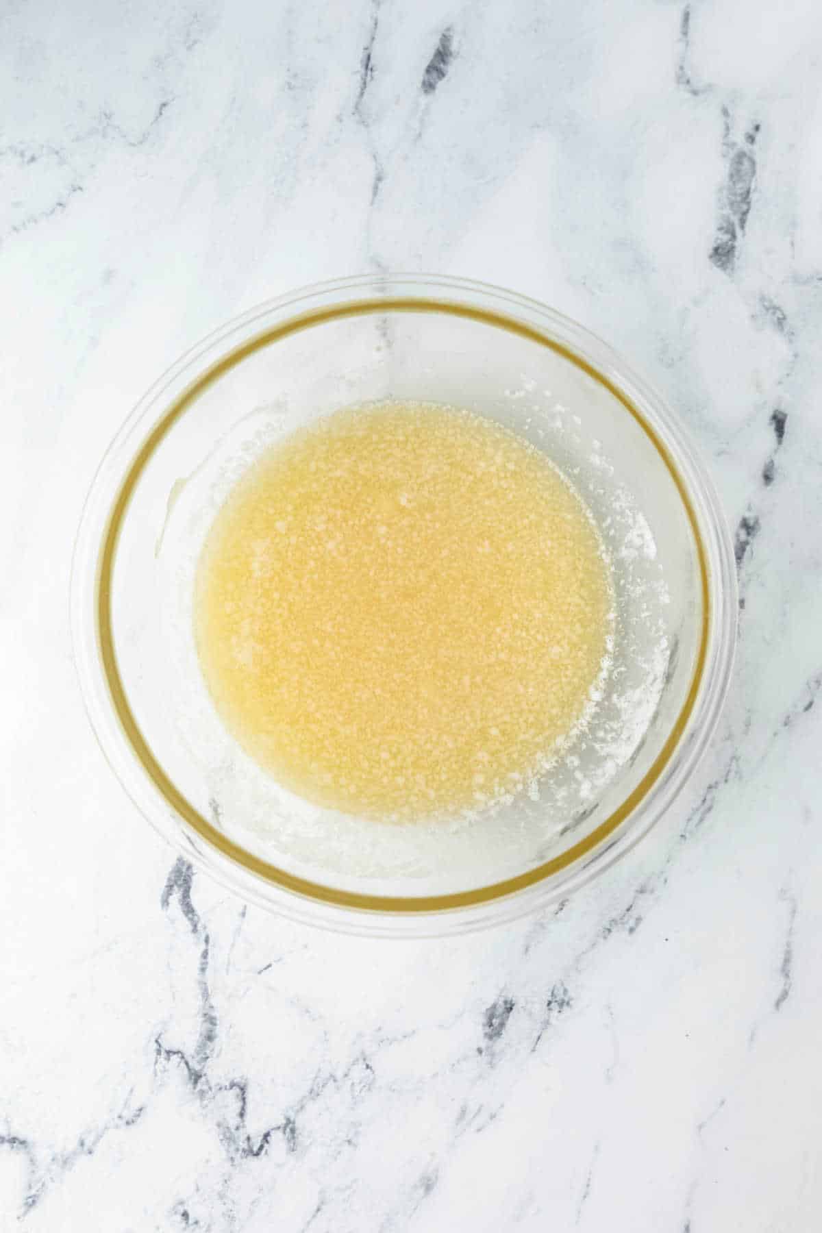 Melted butter in a glass mixing bowl.