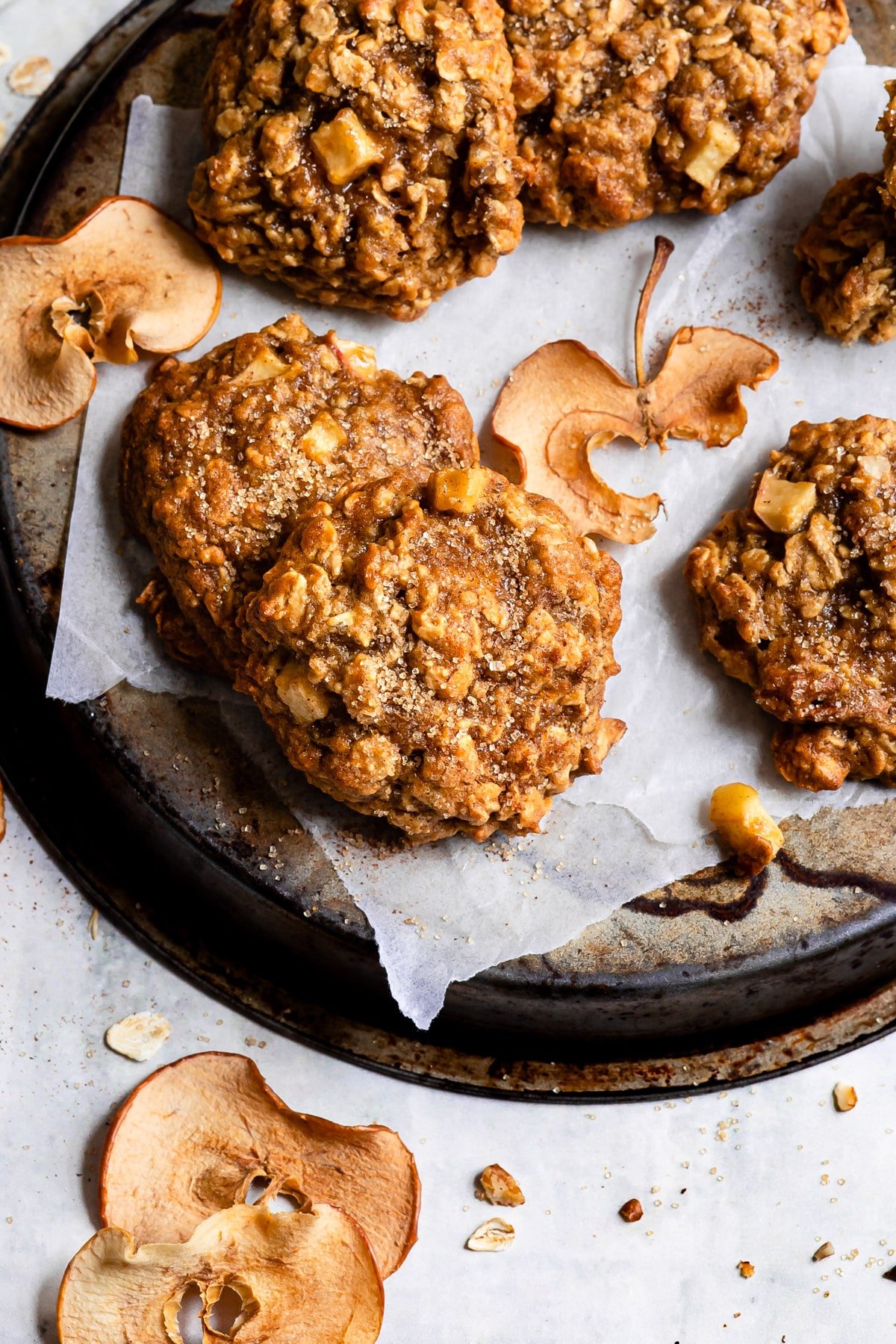 Apple crisp cookies next to pieces of dried apple. 