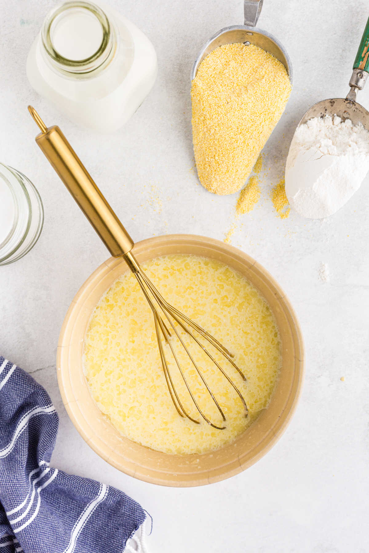 Wet ingredients for cornbread muffins in a mixing bowl. 