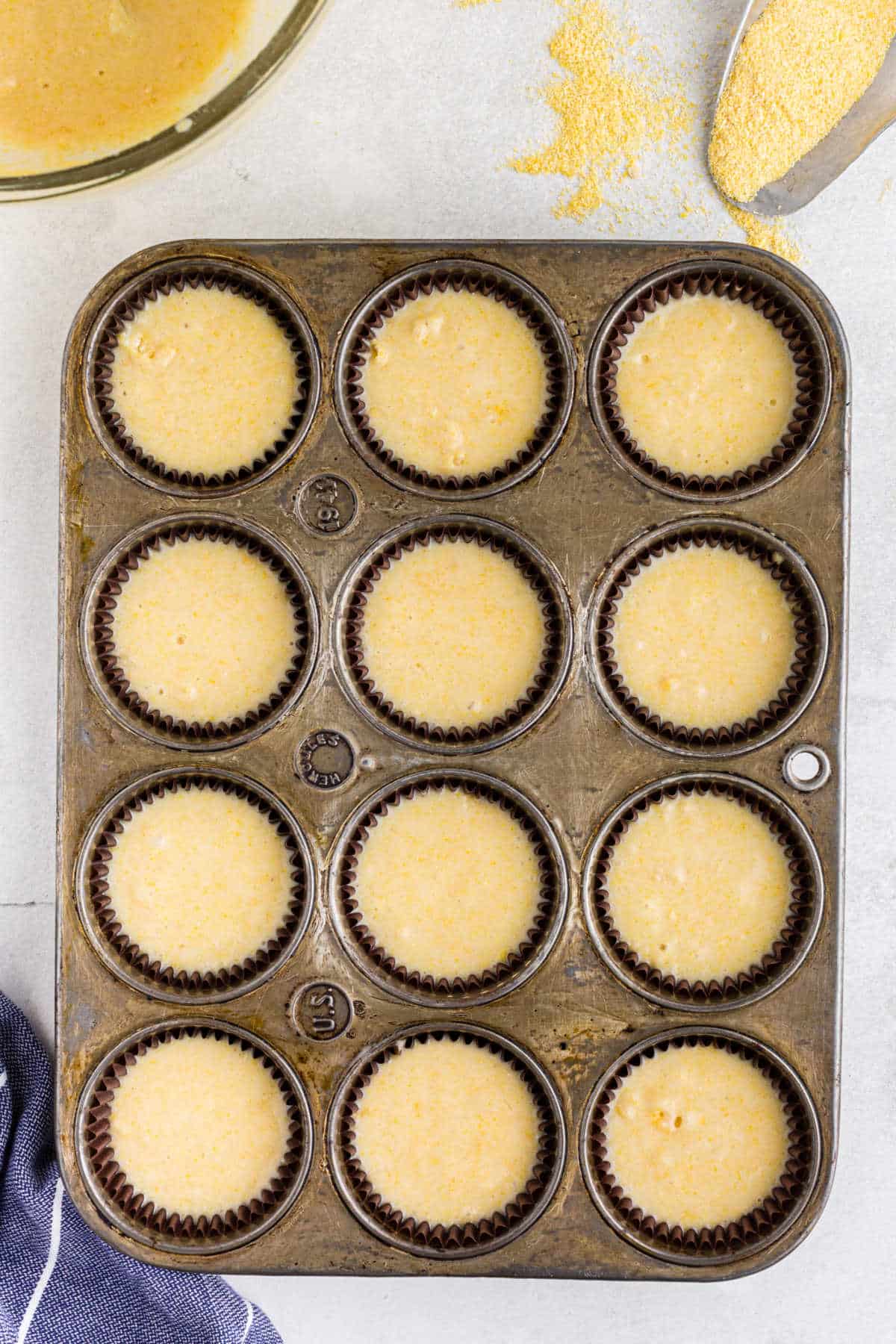 Cornbread muffin batter in a muffin tin.