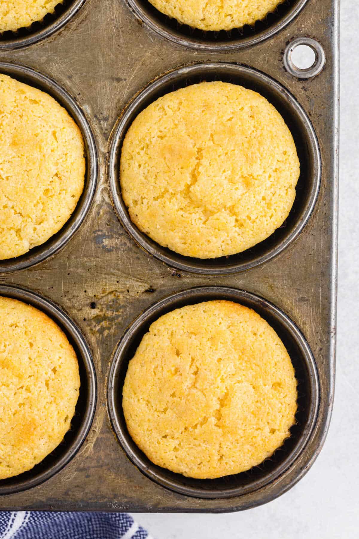 Baked cornbread muffins in a muffin tin. 