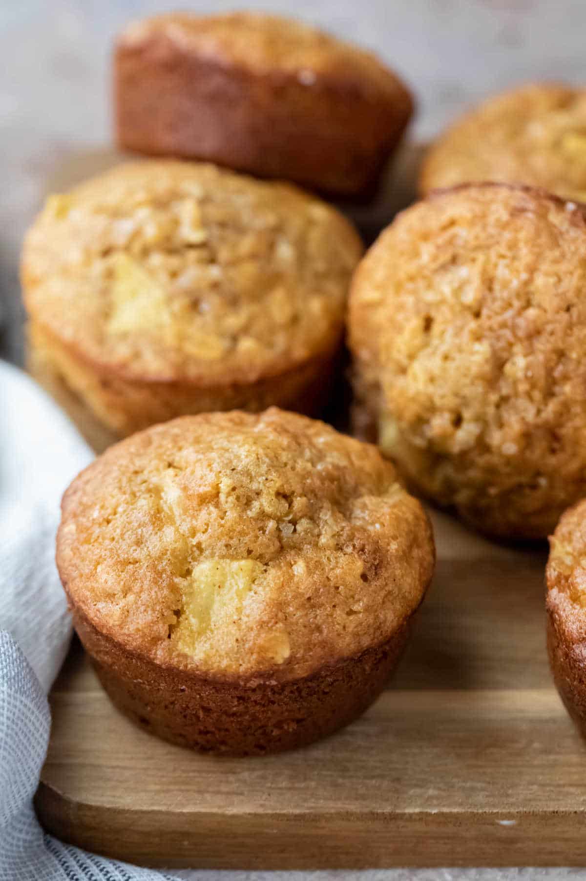 Apple cinnamon oatmeal muffins on a wooden cutting board. 