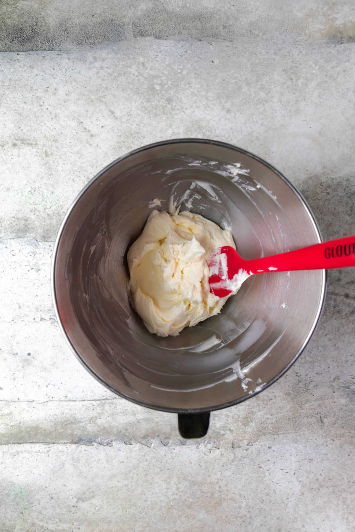 Beaten butter in a silver mixing bowl. 