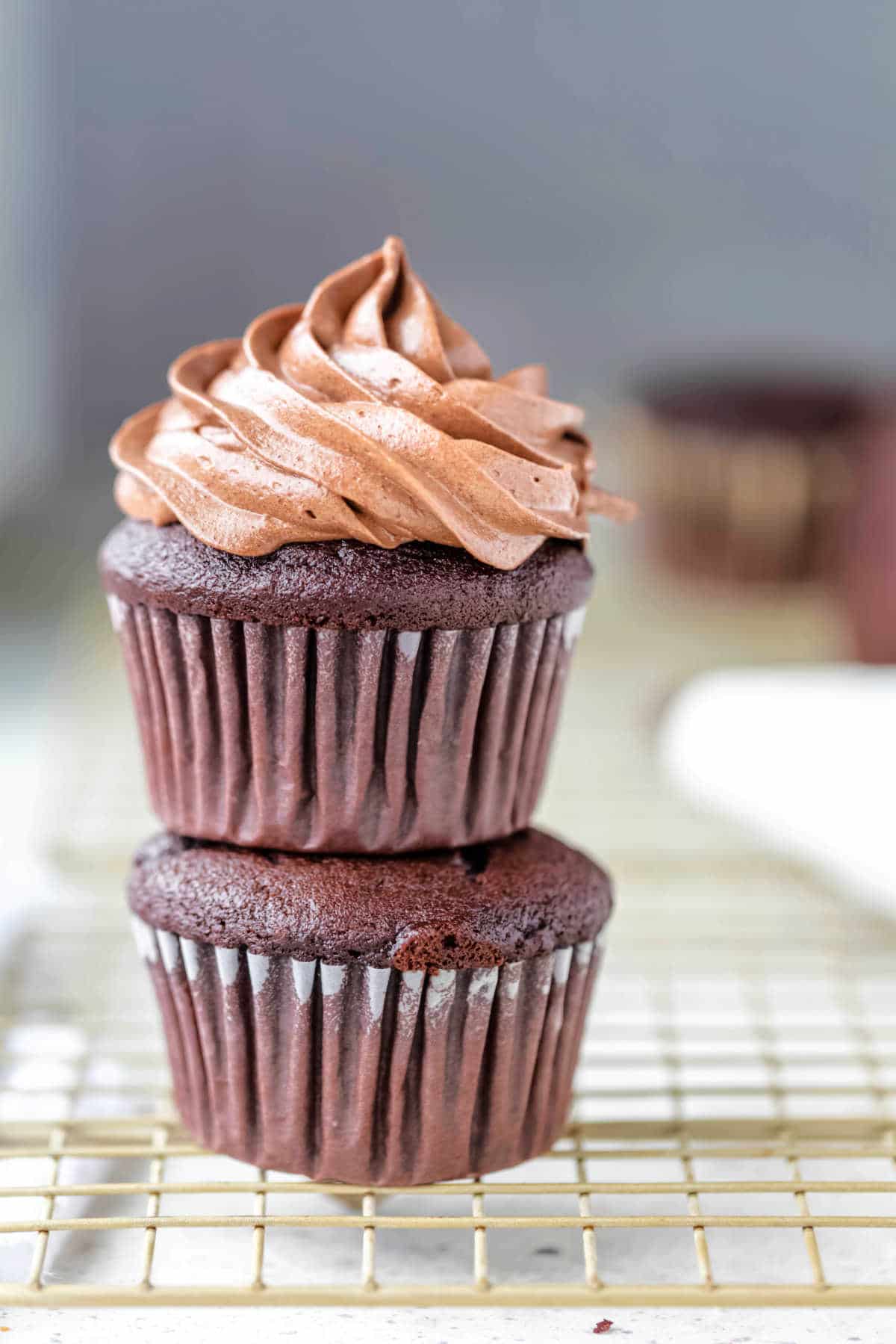 Chocolate Cream Cheese Frosting A frosted cupcake sitting on an unfrosted chocolate cupcake.