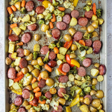 Baked sausage and vegetables on a sheet pan.