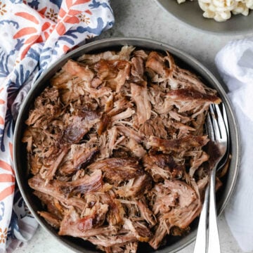 Bowl of slow cooker kalua pork with two forks in it.