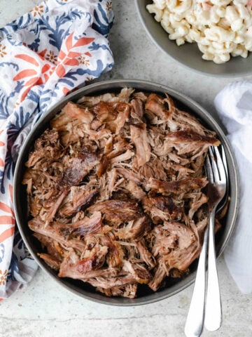 Bowl of slow cooker kalua pork with two forks in it.
