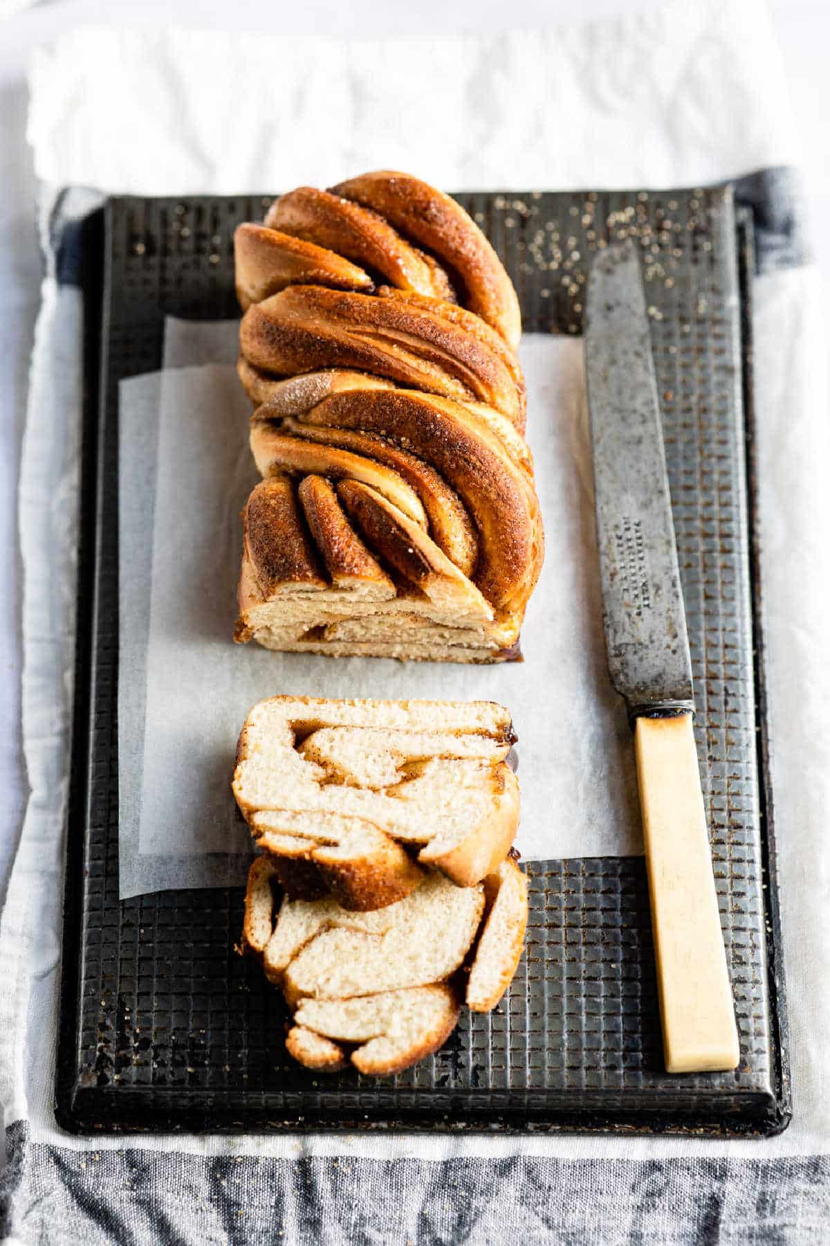 Loaf of cinnamon twist bread with two slices cut from it. 