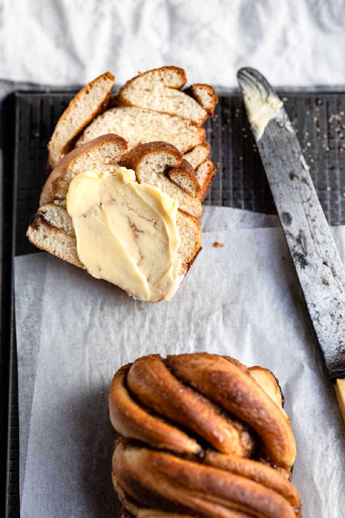 Two slices of cinnamon twist bread next to a knife. 