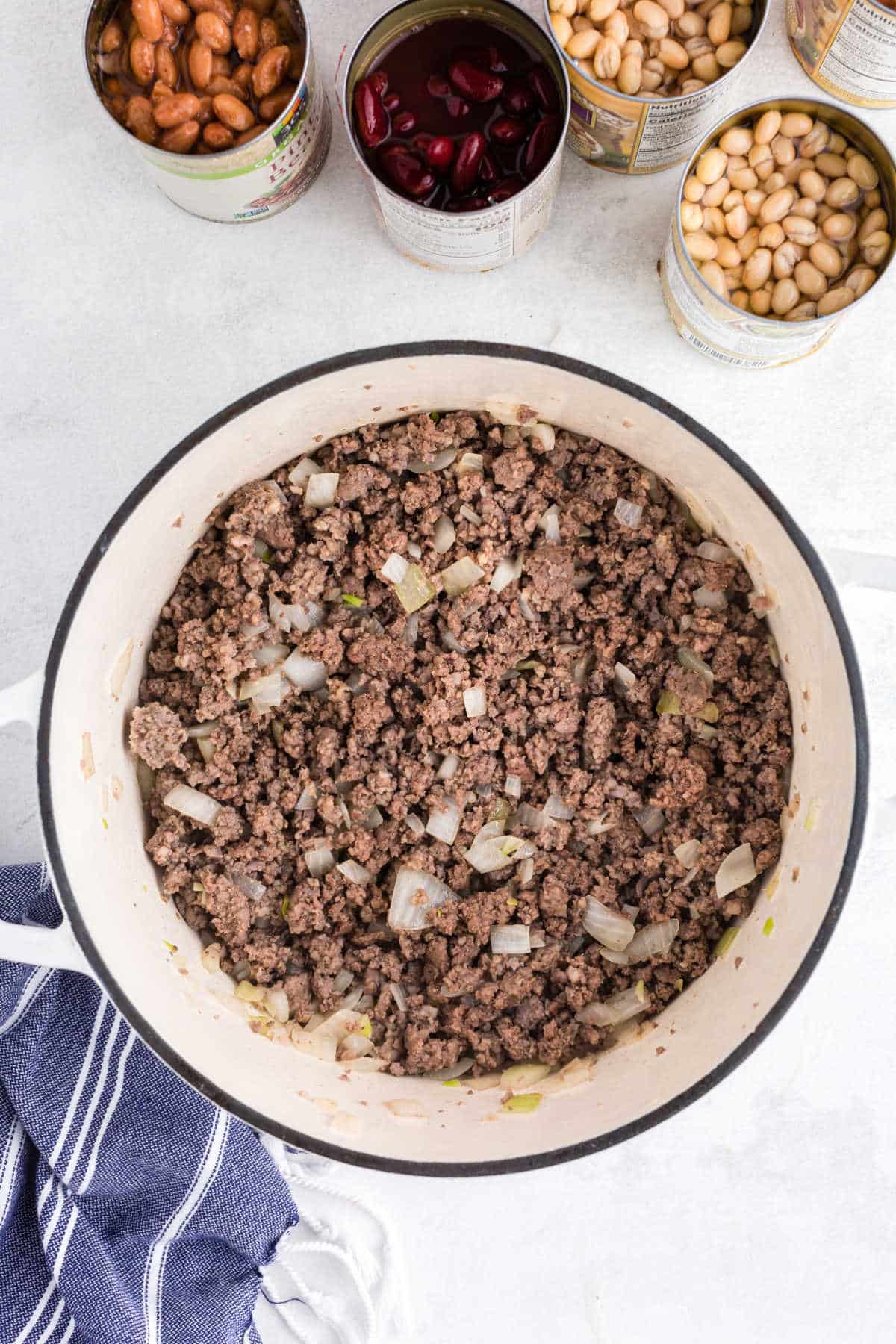 Browned ground beef sausage and onion in a Dutch oven.