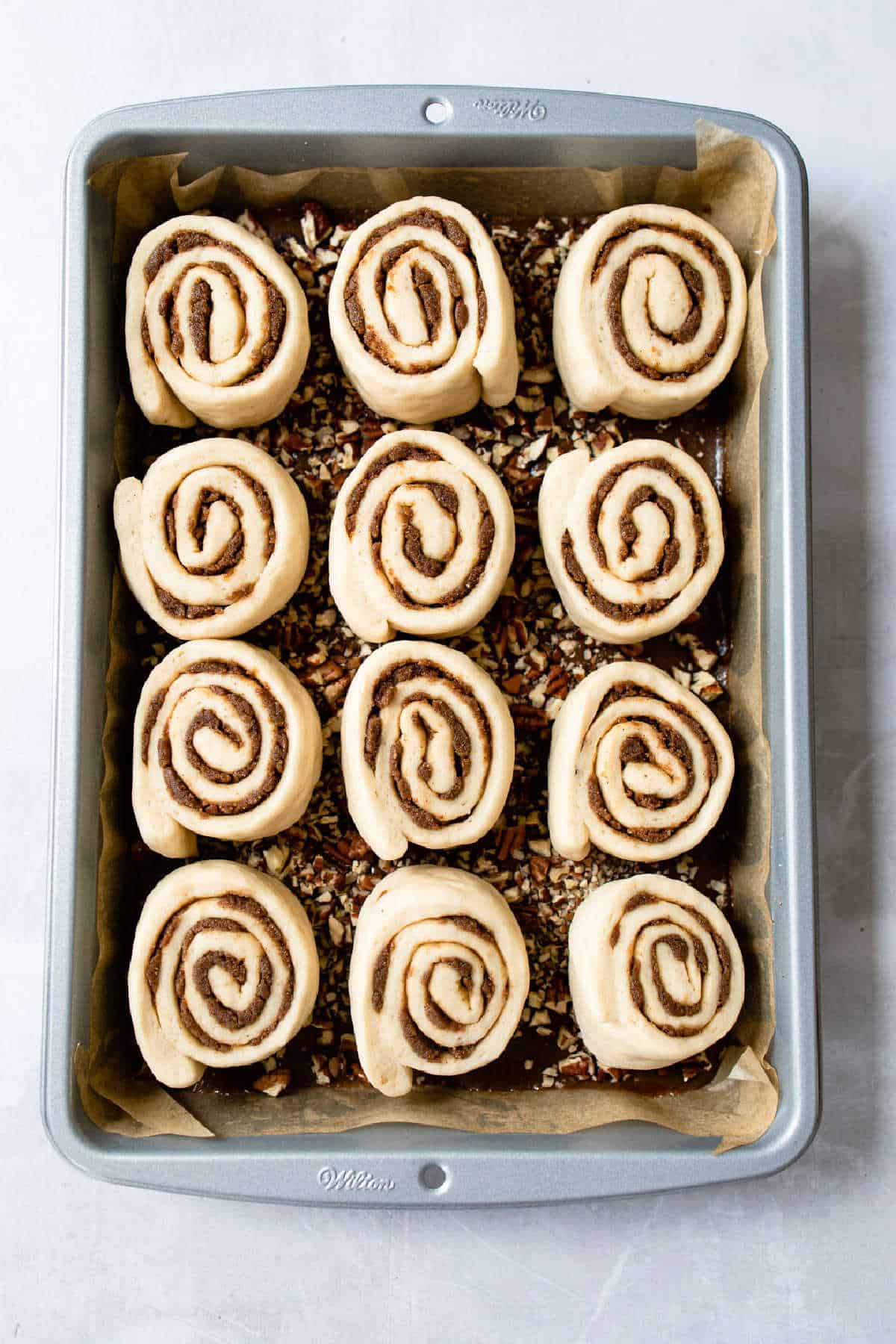 Unbaked caramel rolls in a pan.