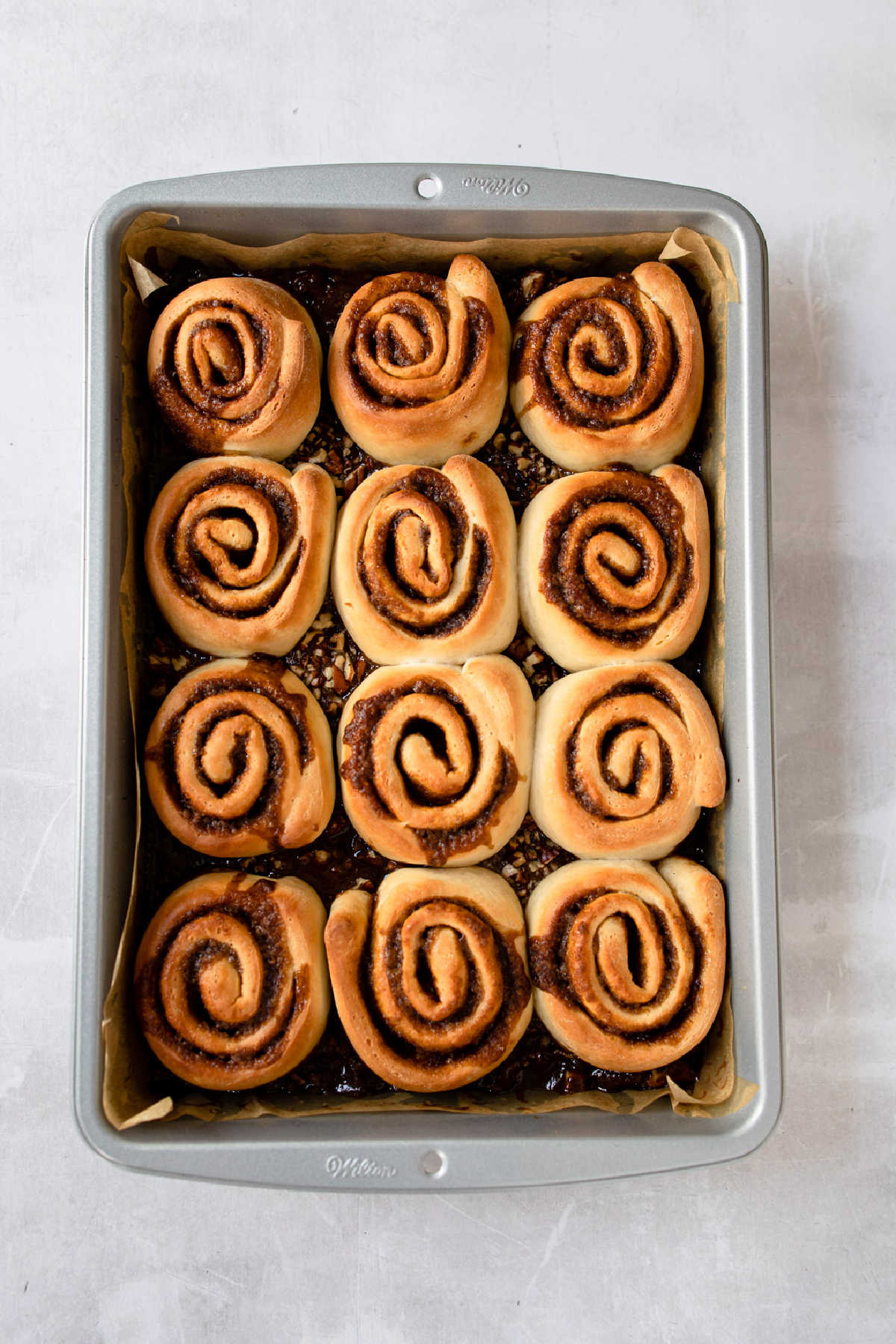 Baked caramel rolls in a baking pan.