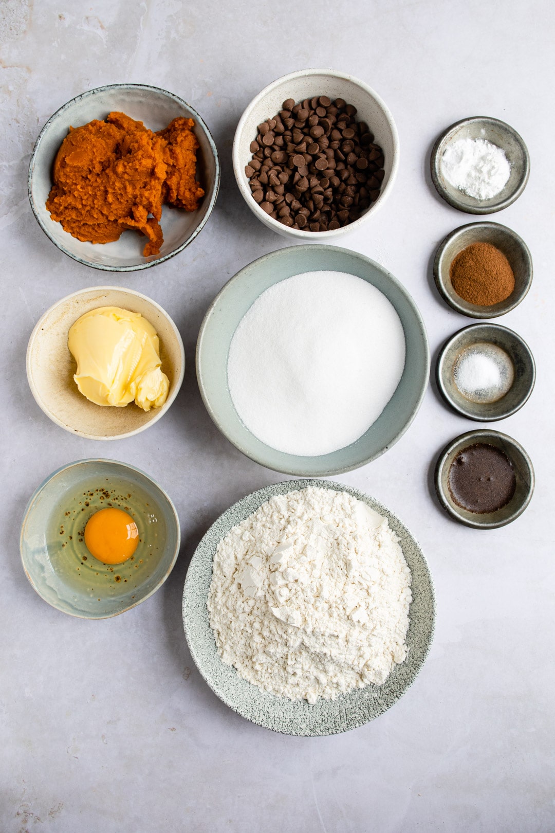 Ingredients for pumpkin chocolate chip cookies on a gray background. 