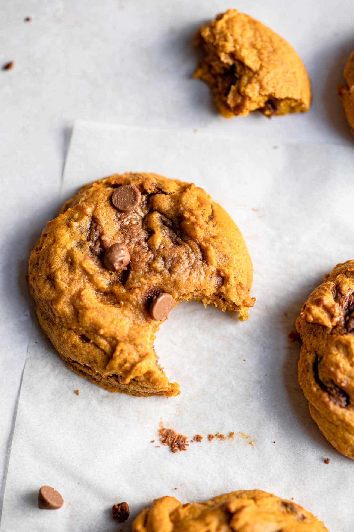 Pumpkin chocolate chip cookie with a bite missing. 