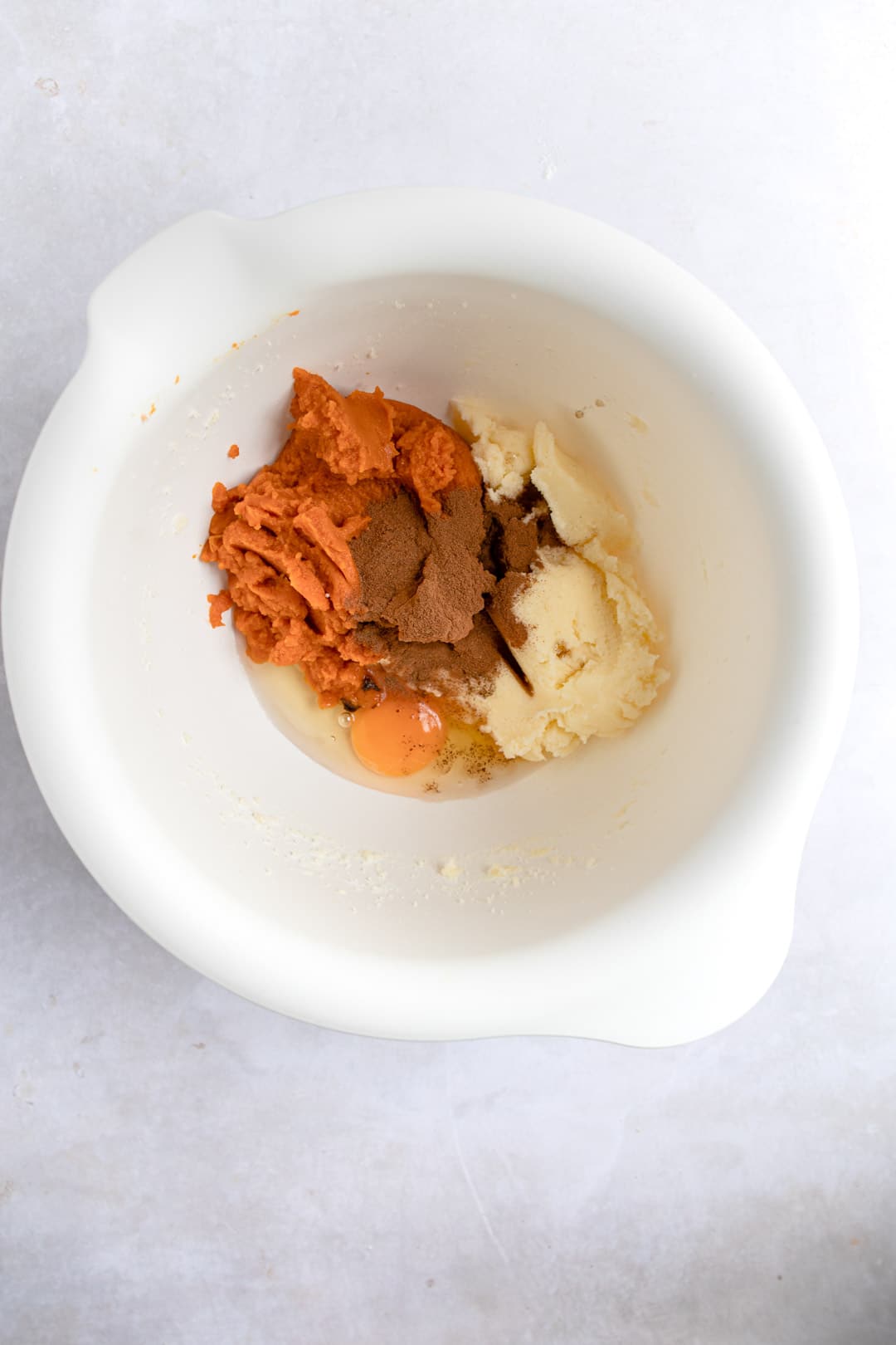 Pumpkin and spices in a white mixing bowl. 