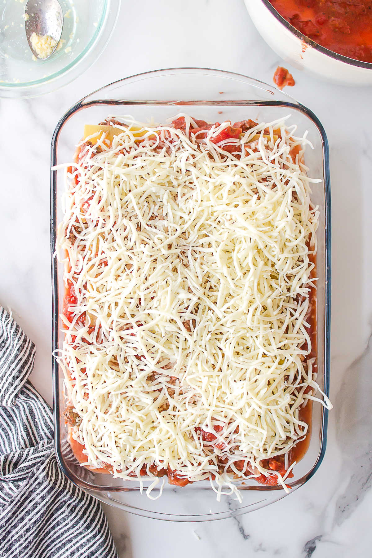 Unbaked freezer lasagna in a pan.