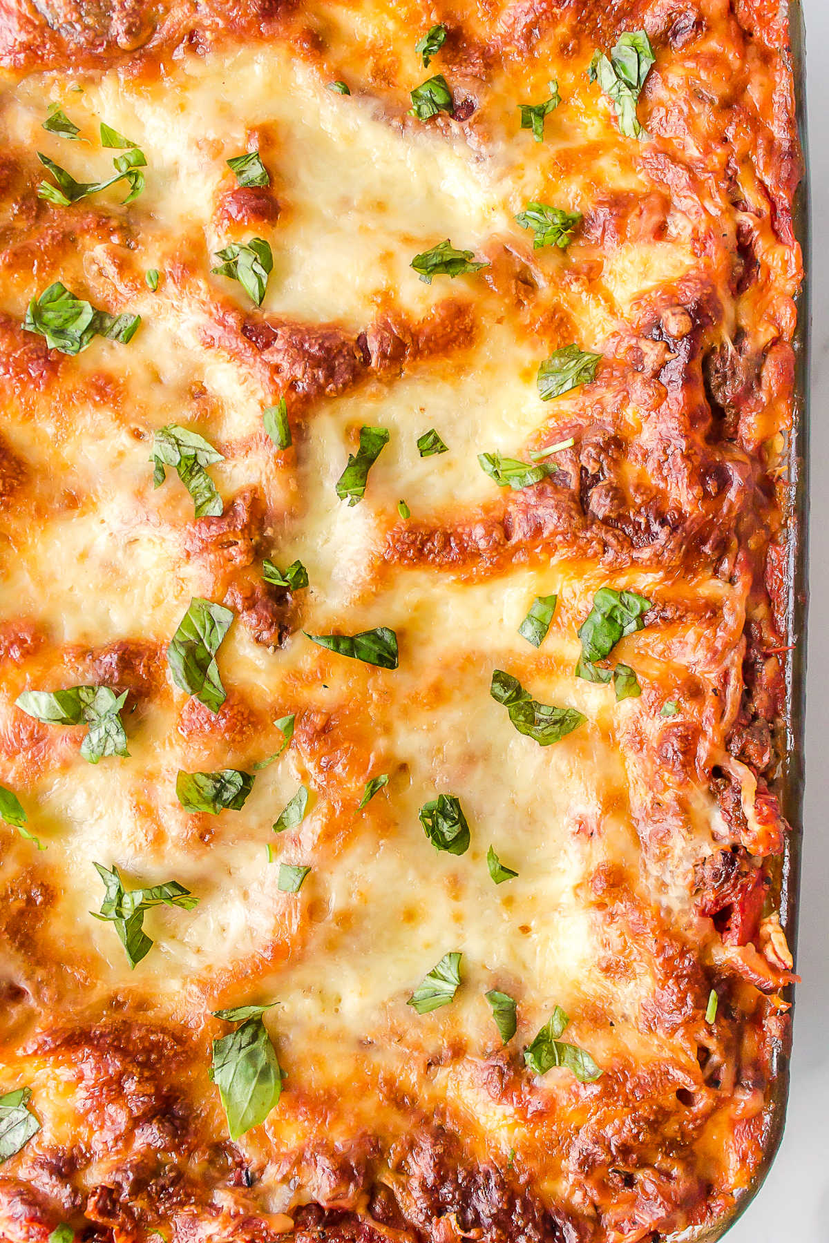 Close up overhead photo of a baked lasaga in a pan.