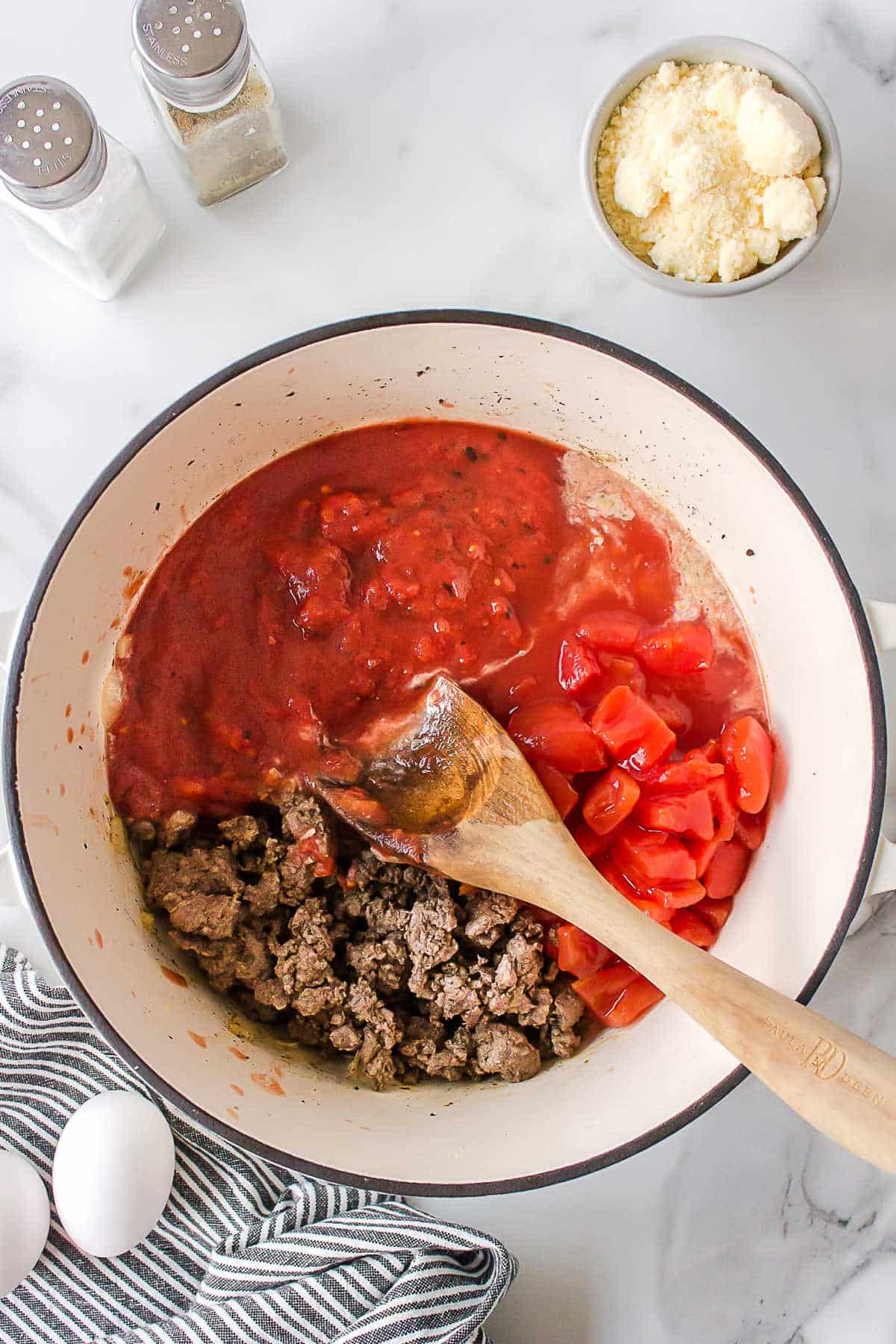 Browned ground beef and tomatoes in a Dutch oven.