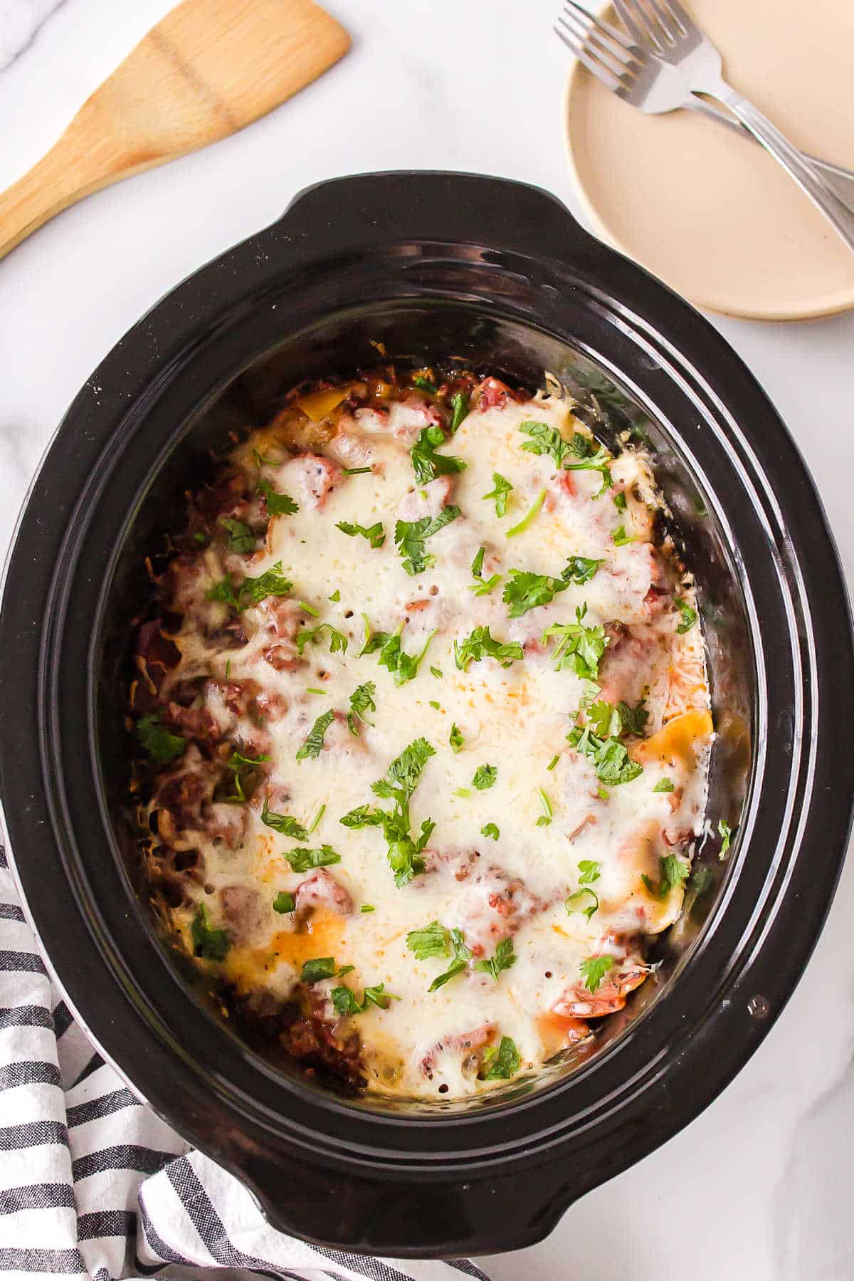 Lasagna in a slow cooker insert.