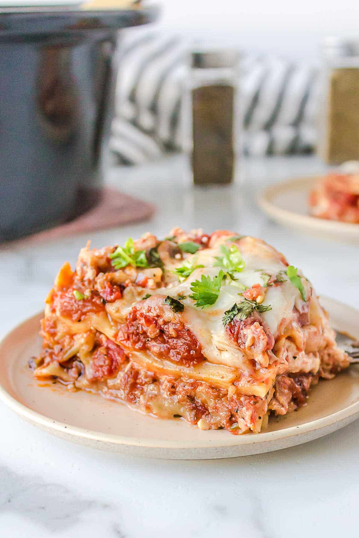 Slice of crock pot lasagna on a white plate. 