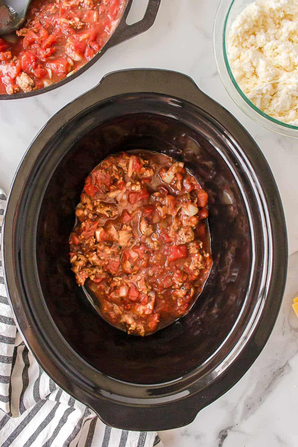 Sauce in the bottom of a slow cooker insert. 