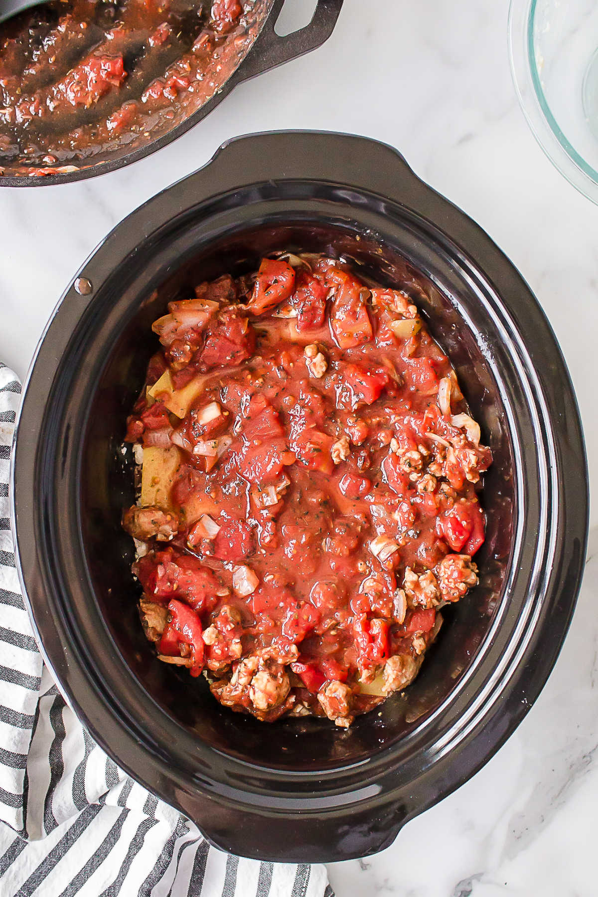 Sauce over noodles in a slow cooker.