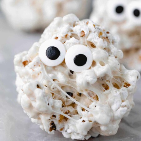 Popcorn ball with candy eyes on it.