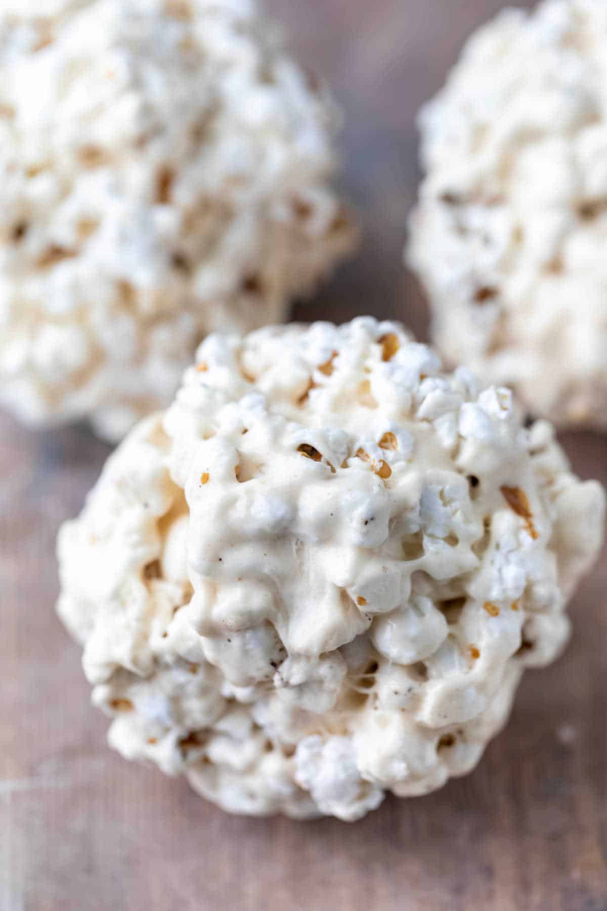 Marshmallow popcorn balls on a sheet of wax paper. 