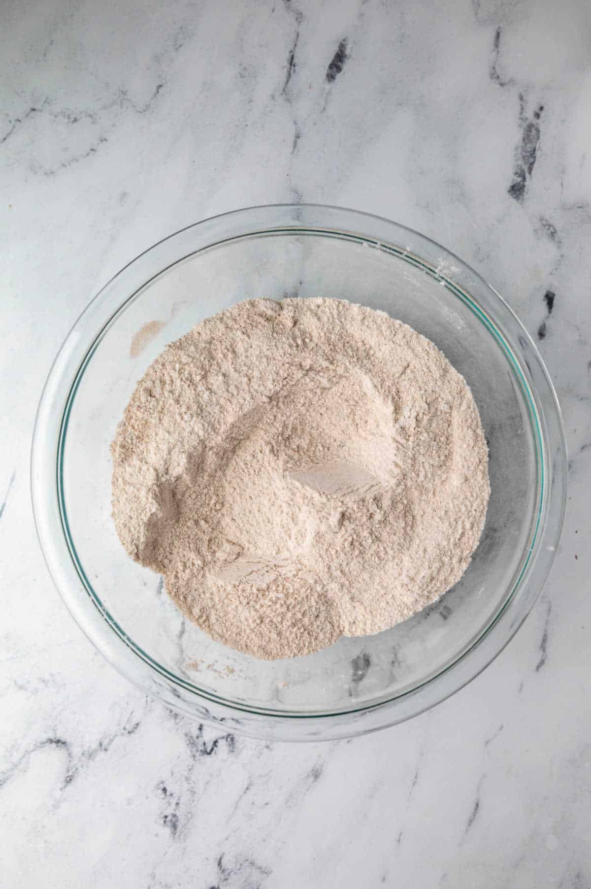 Flour and cinnamon in a glass mixing bowl. 