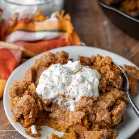 Plate of pumpkin pie crisp next to a orange plaid napkin.