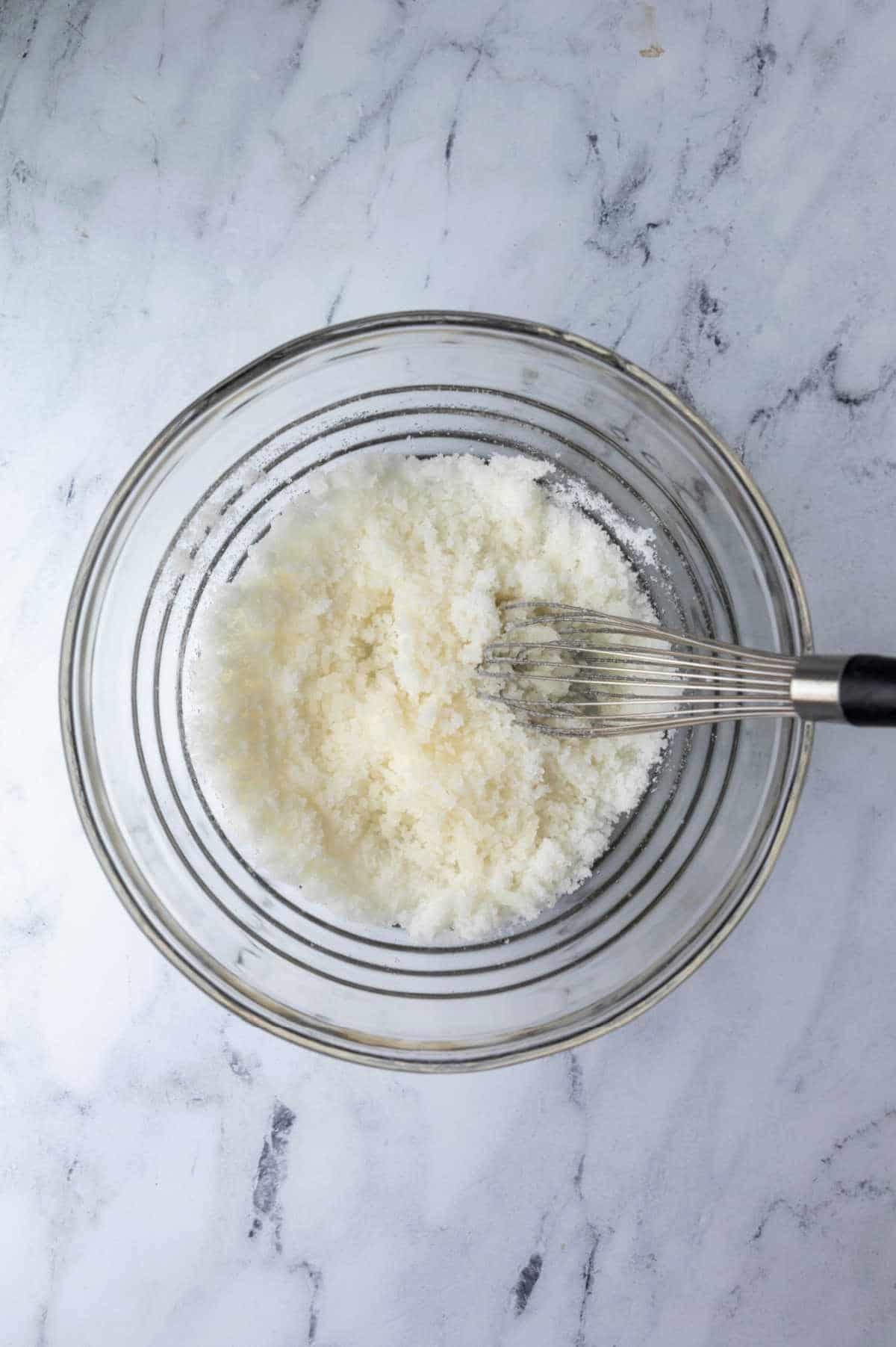 Sugar and oil in a white mixing bowl.