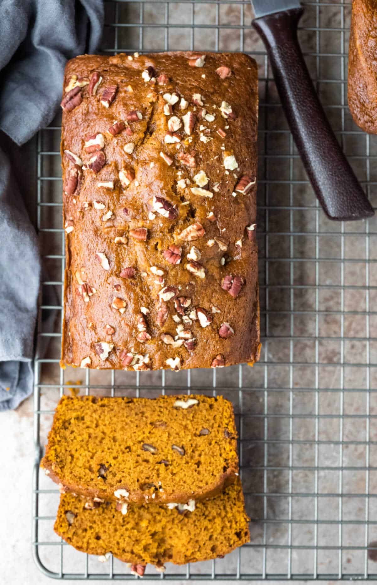Loaf of pumpkin nut bread with two slices cut. 