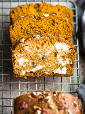 Buttered slice of pumpkin nut bread in a stack.