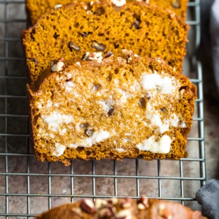 Buttered slice of pumpkin nut bread in a stack.