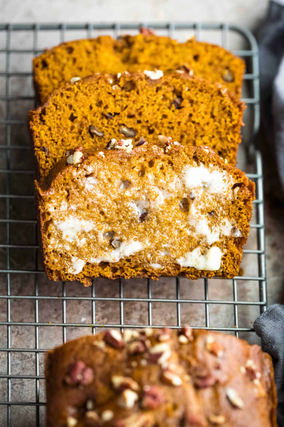 Buttered slice of pumpkin nut bread in a stack. 