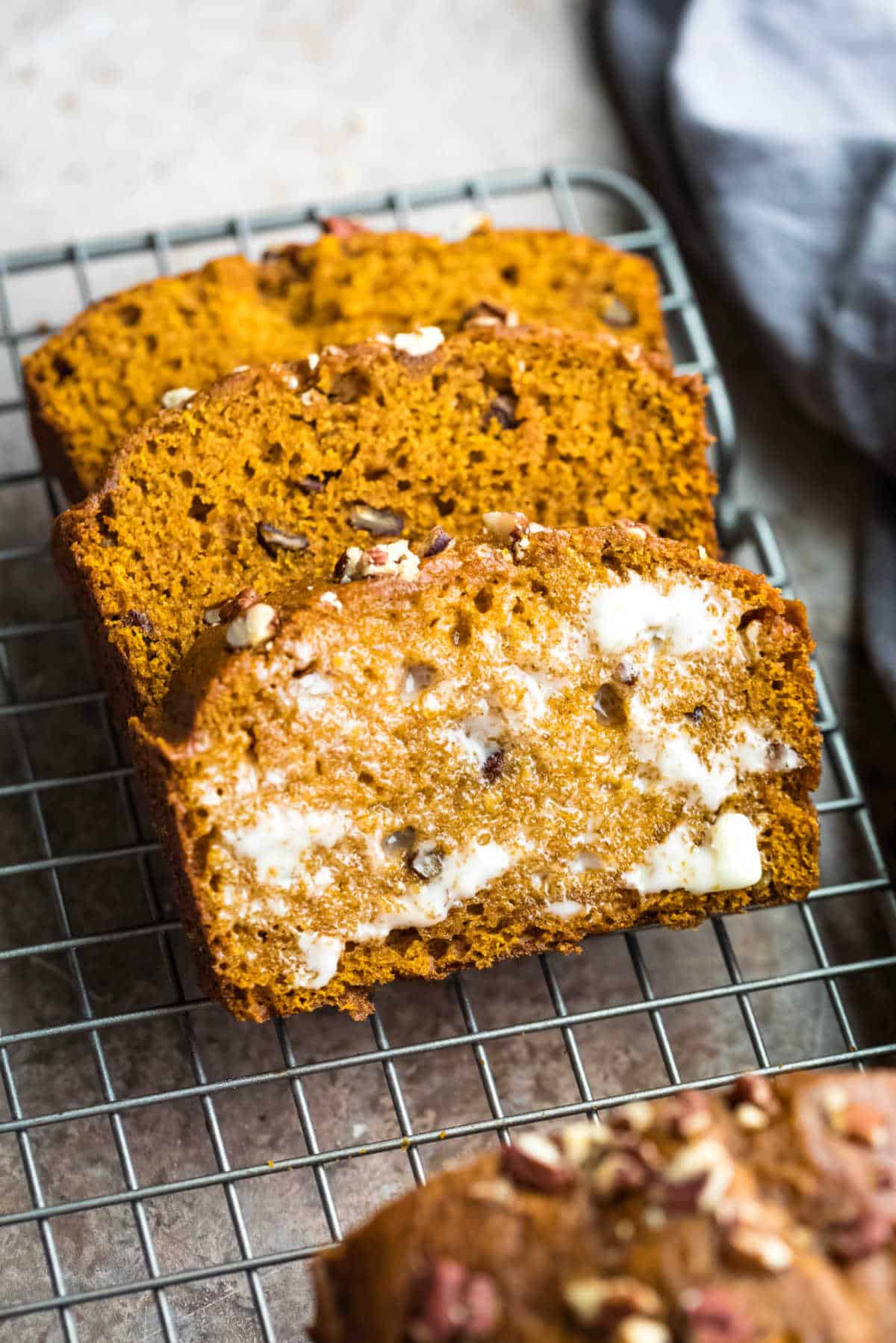 Three slices of pumpkin nut bread at an angle. 