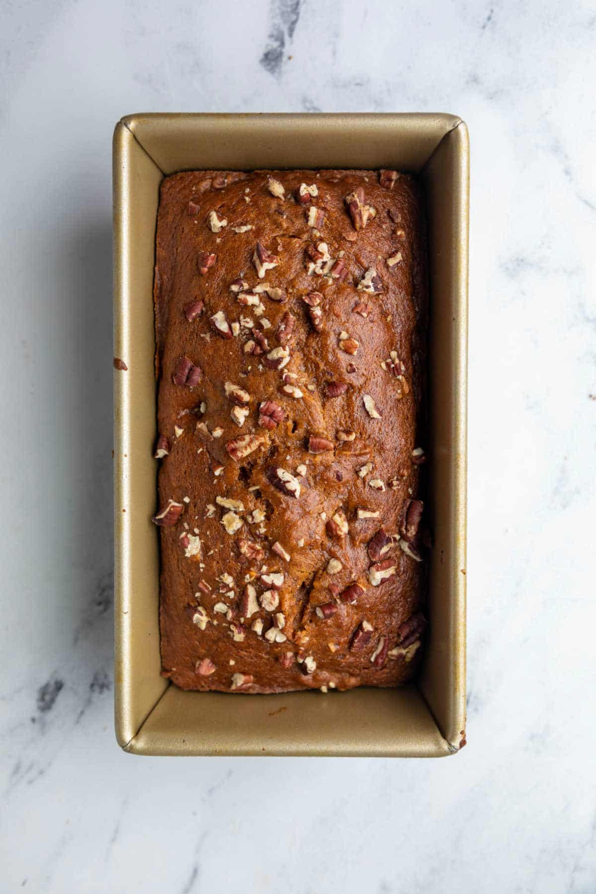 Baked pumpkin nut bread in a loaf pan.