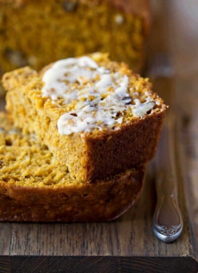 Half of a buttered slice of buttermilk pumpkin bread on a slice of pumpkin bread.