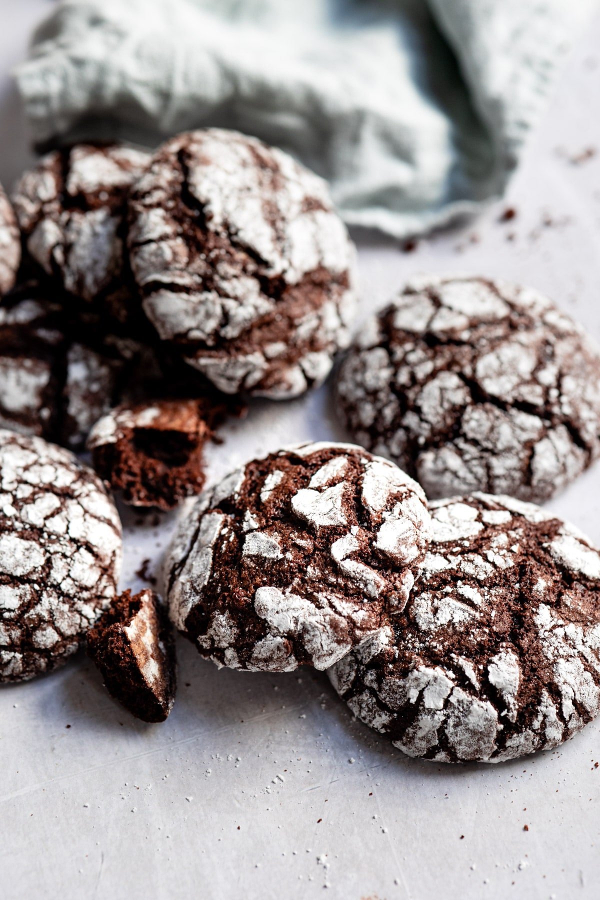 Chocolate crinkle cookies stacked around on each other. 