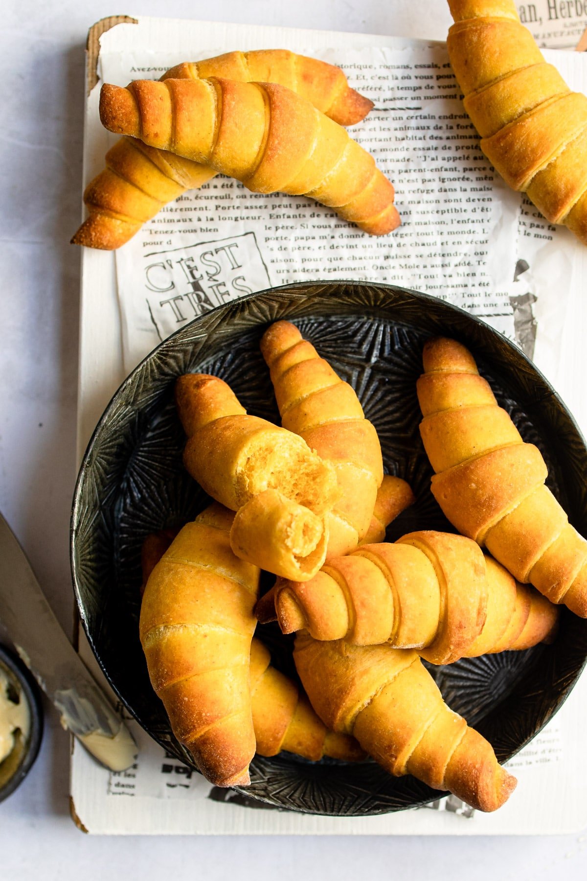 Pumpkin crescent rolls on a black plate. 