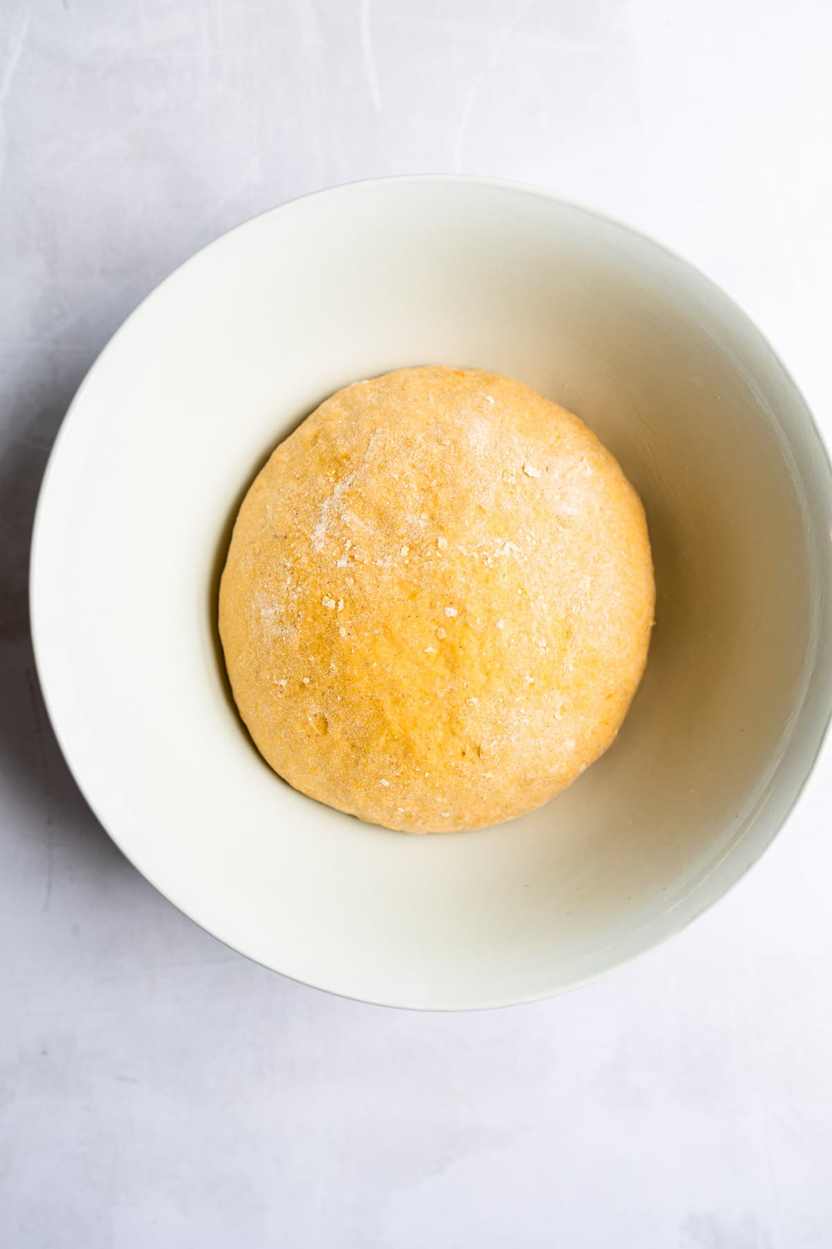 Risen dough in a white bowl. 