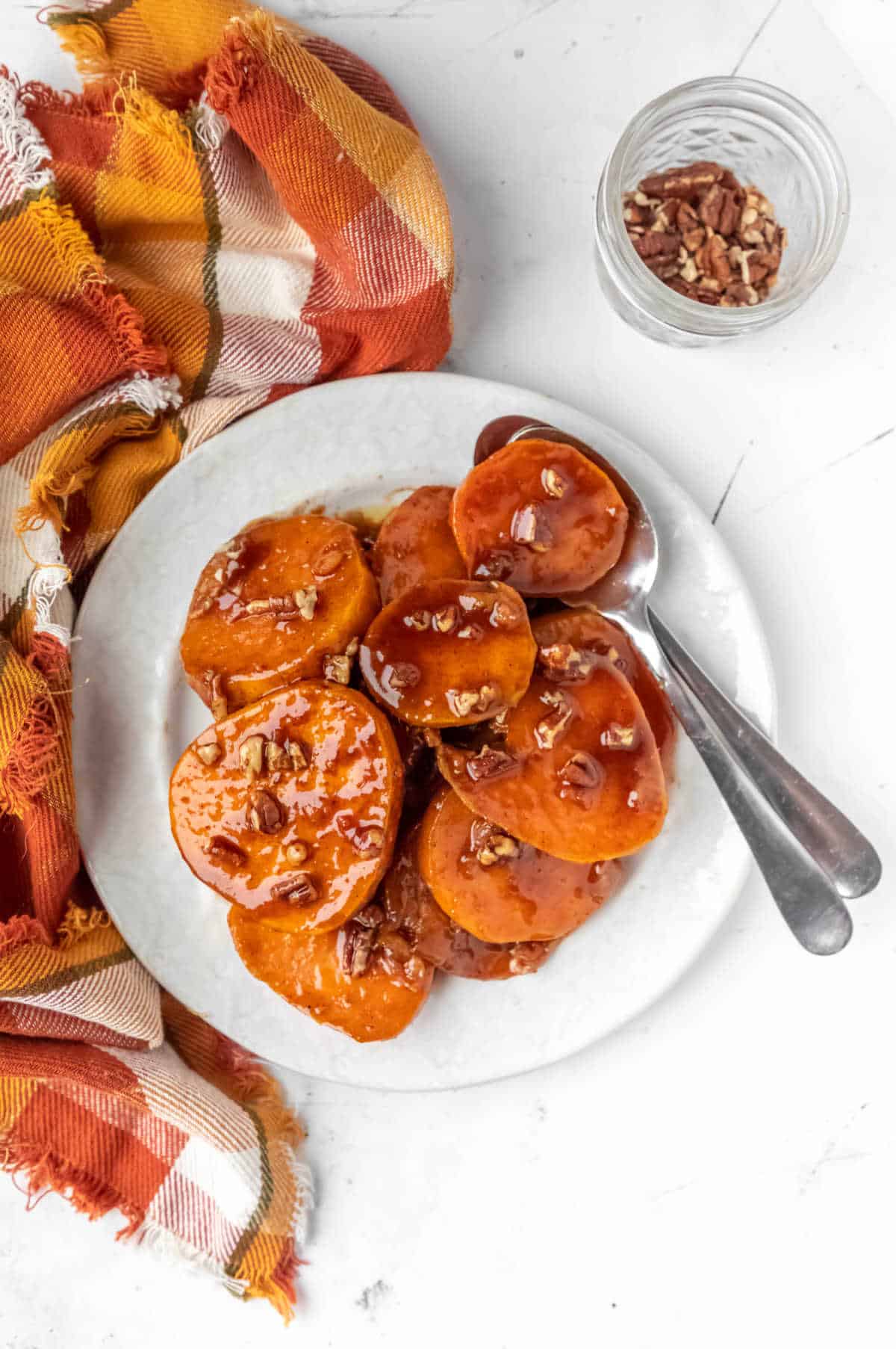 White plate with candied sweet potatoes on it. 